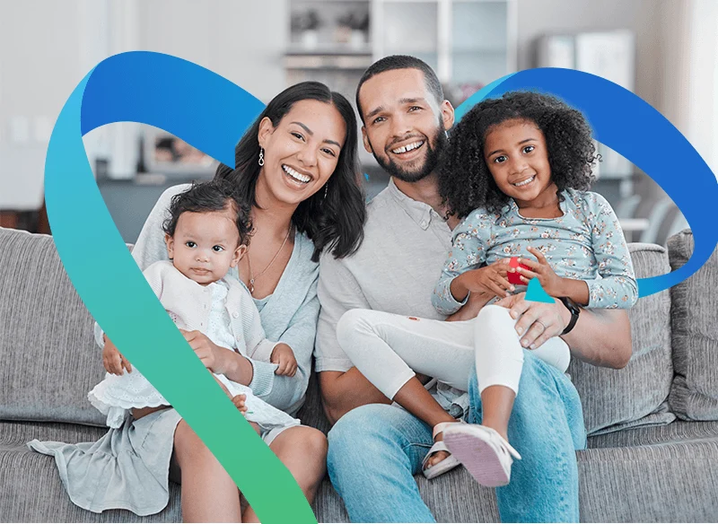 Família reunida no sofá, com o laço azul e verde da Cedae Saúde.
